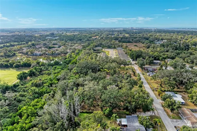 an aerial view of residential houses with outdoor space and trees