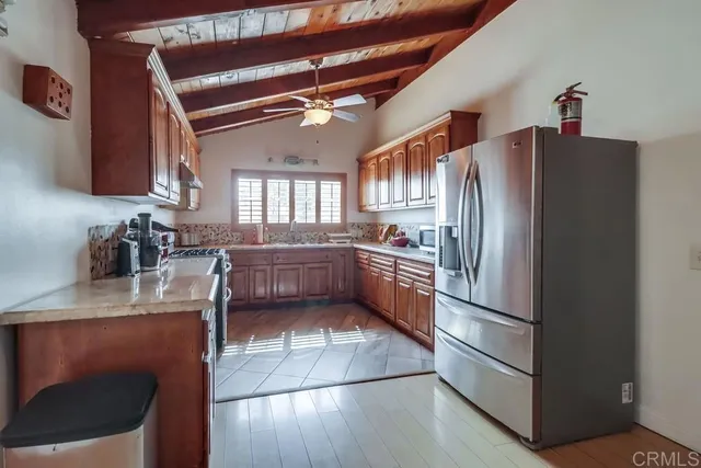 a kitchen with stainless steel appliances granite countertop a refrigerator a sink a stove and island