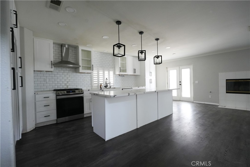 1464 Augusta Street Beaumont, CA 92223 - Photo 7 of 32 a kitchen with stainless steel appliances kitchen island granite countertop a stove a sink and a refrigerator