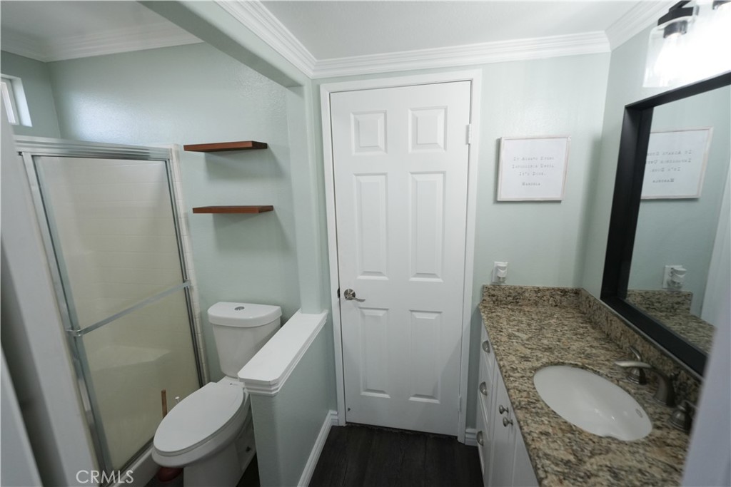 1464 Augusta Street Beaumont, CA 92223 - Photo 10 of 32 a white toilet sitting next to a bathroom sink and a mirror