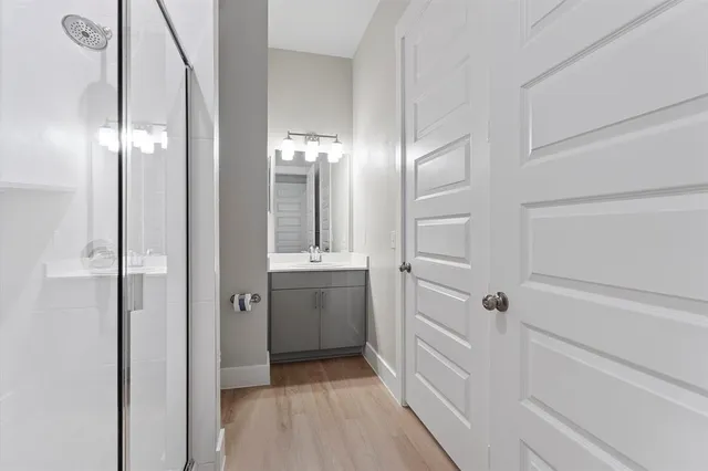 a bathroom with a double vanity sink a toilet and shower