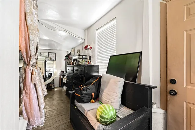 a living room with furniture a flat screen tv and a floor to ceiling window