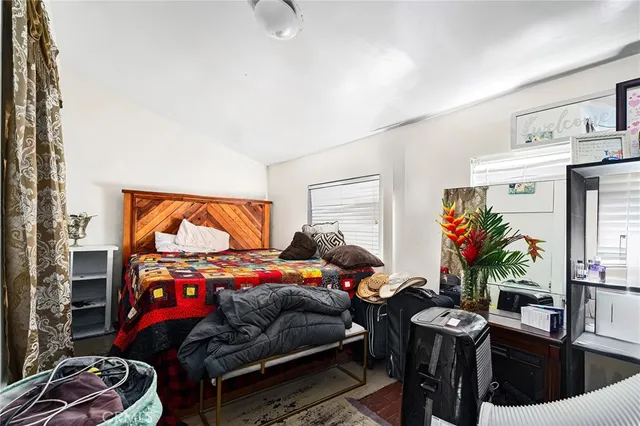 a bedroom with bed and a potted plant