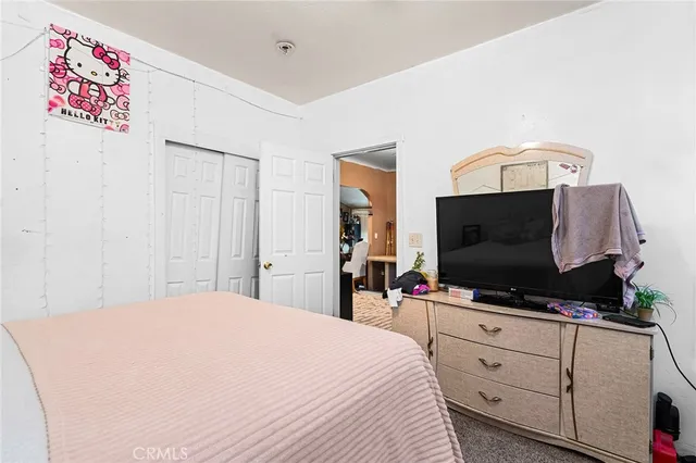 a bedroom with a bed and a flat screen tv