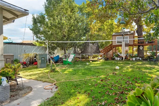 a view of a backyard with table and chairs with wooden fence