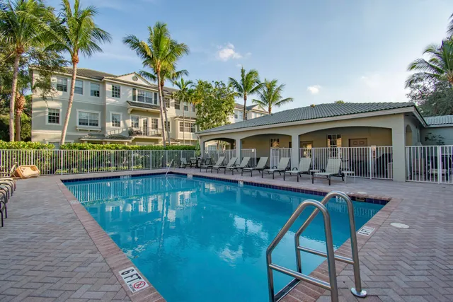 a view of house with swimming pool and sitting area