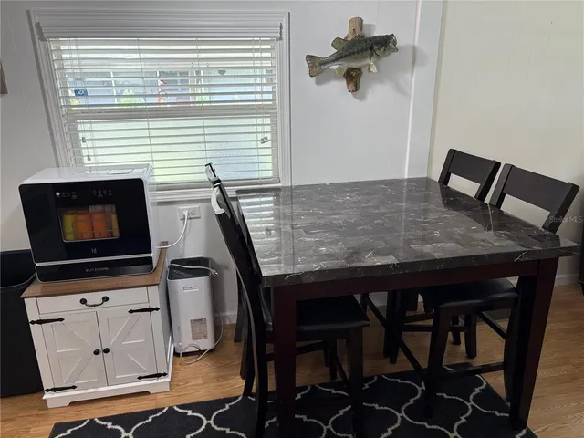 a kitchen view with table chairs and flat screen tv