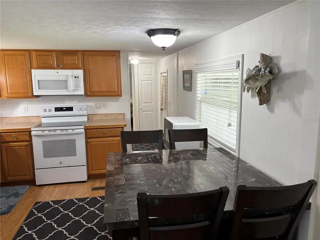 a kitchen with a table chairs stove and cabinets