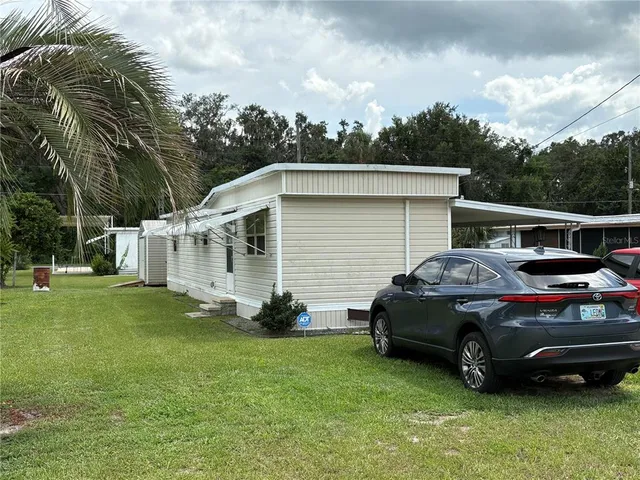 a car parked in front of a house with a garden
