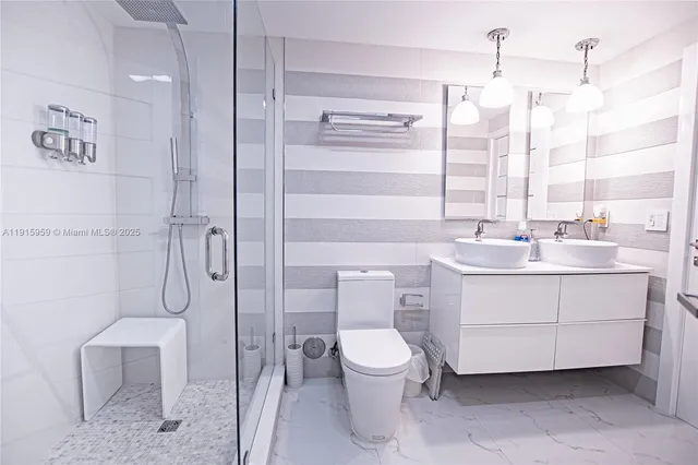 a bathroom with a sink a toilet and shower