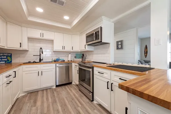 a kitchen with granite countertop white cabinets and white appliances