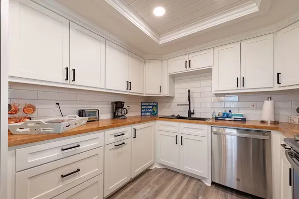 a kitchen with kitchen island white cabinets and white appliances