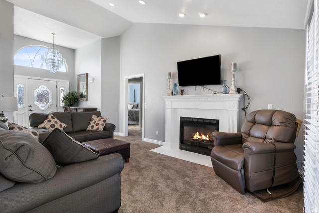 13176 Day Court Draper, UT 84020 - Photo 4 of 45 Carpeted living room with a tile fireplace, vaulted ceiling, and hanging lights
