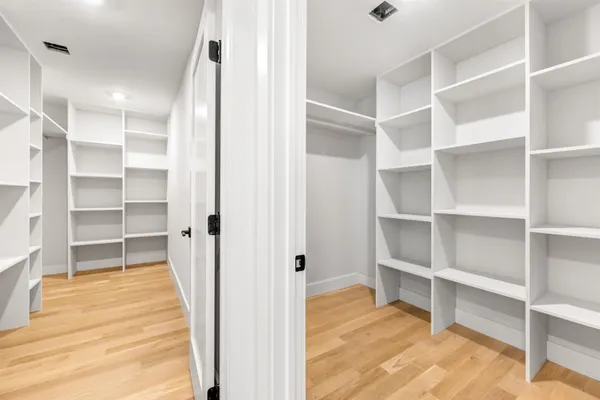 a view of walk in closet with empty racks