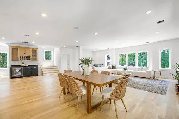 a dining hall with stainless steel appliances granite countertop a stove a sink a dining table and chairs