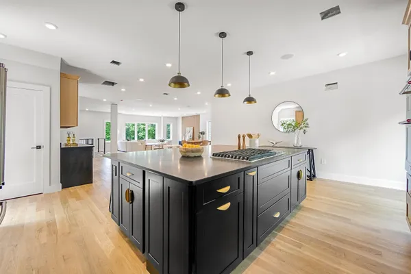 a kitchen with stainless steel appliances granite countertop a sink a stove and a wooden floors