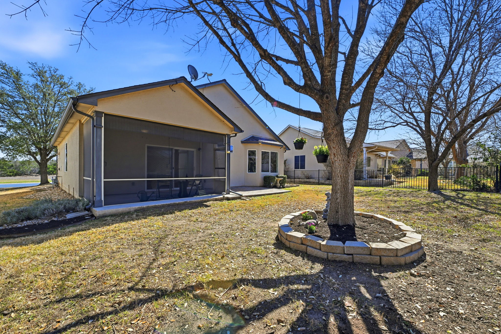 708 Texas Drive Georgetown, TX 78633 - Photo 25 of 27 Rear view of home with partially fenced yard and mature trees with flower bed.