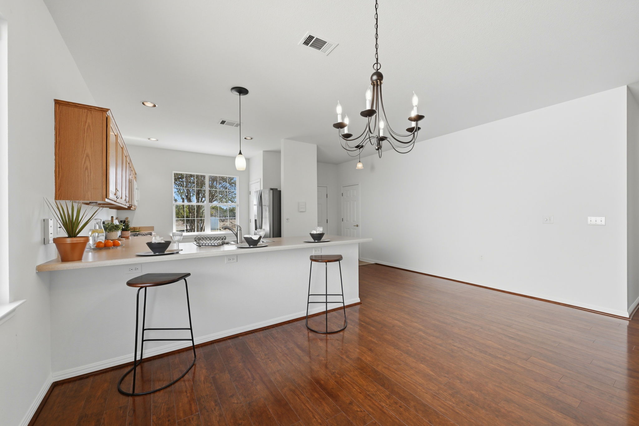708 Texas Drive Georgetown, TX 78633 - Photo 5 of 27 Kitchen featuring a breakfast bar area, a peninsula, wood finish cabinets, and light countertops.