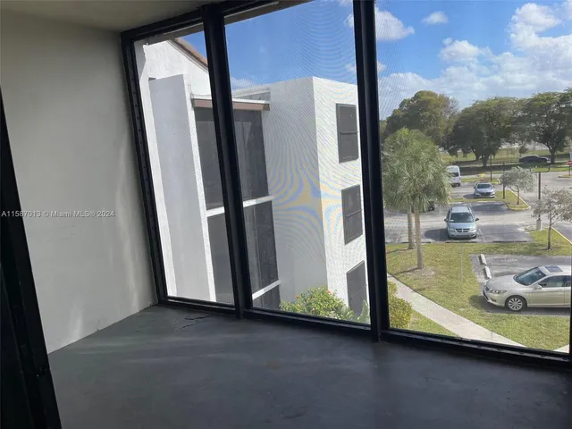 an empty room with a fireplace and a floor to ceiling window