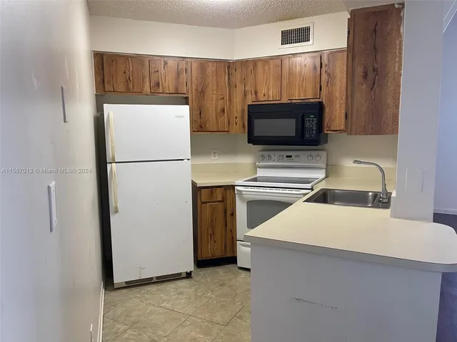 a kitchen with a refrigerator sink and microwave