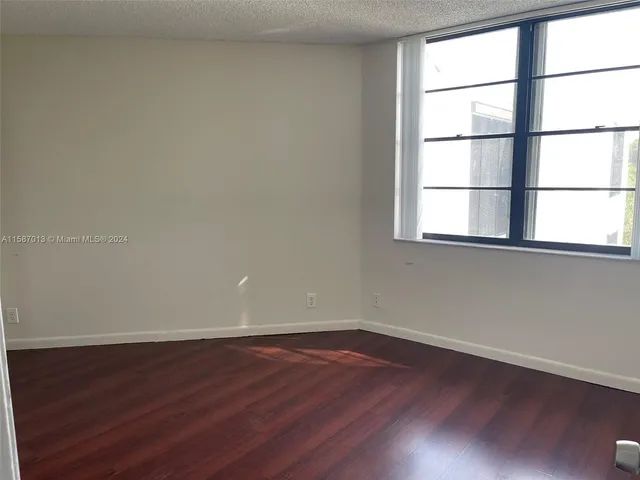 a view of a room with wooden floor and a window