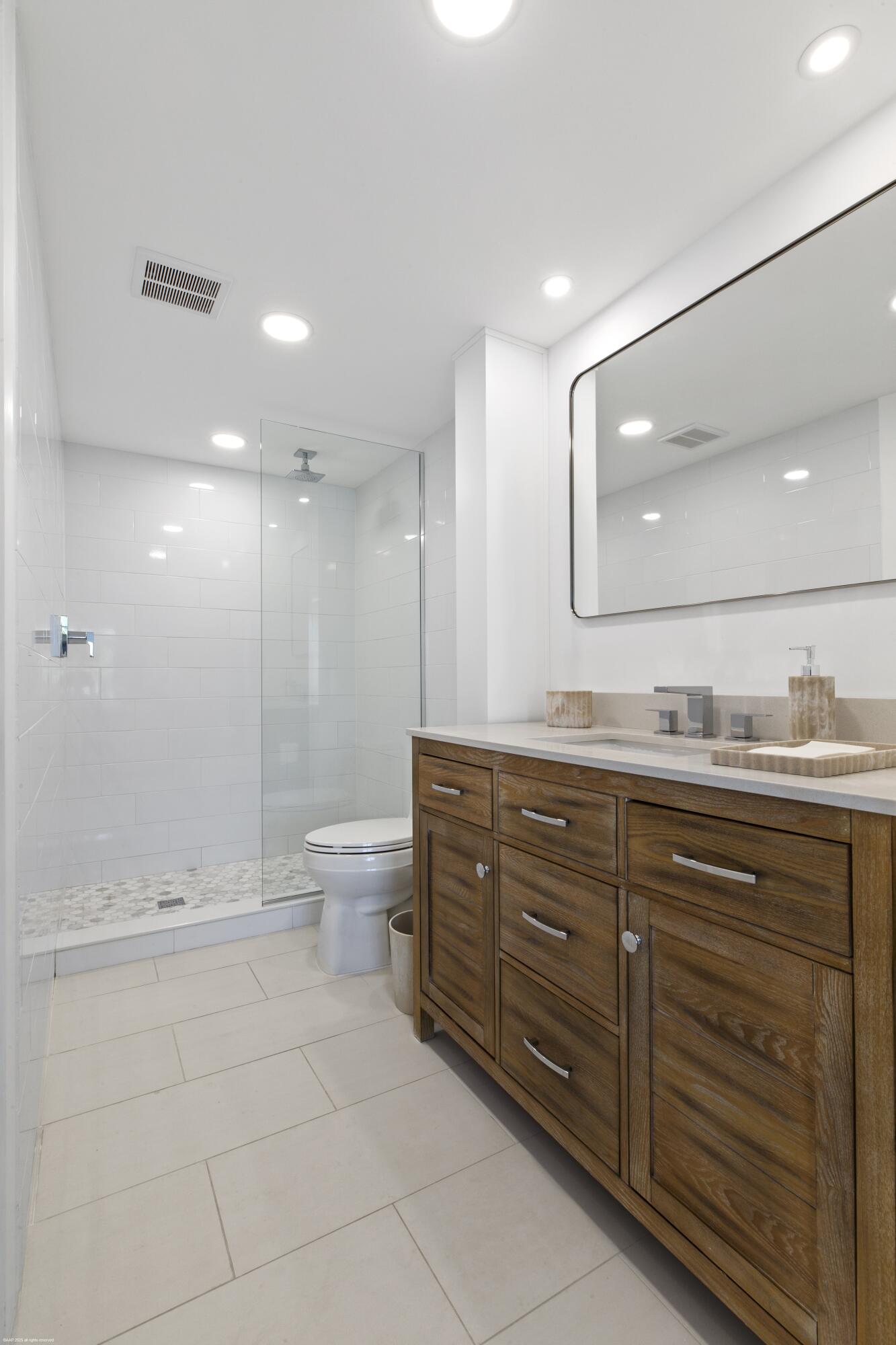 1030 Sugar Sands Boulevard, Unit 267 Singer Island, FL 33404 - Photo 29 of 51 a bathroom with a granite countertop sink a toilet and a large mirror