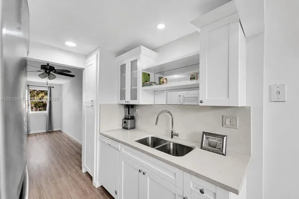 a kitchen with white cabinets and sink