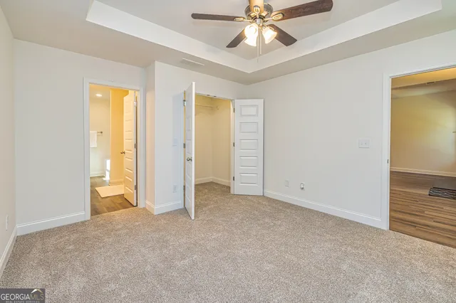 an empty room with closet and a chandelier fan