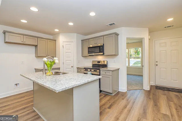 a kitchen that has a microwave a stove and white cabinets