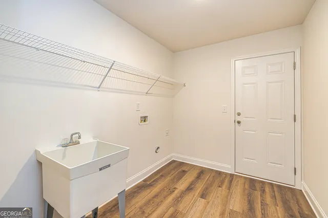 a view of a room that has a sink and dishwasher with wooden floor