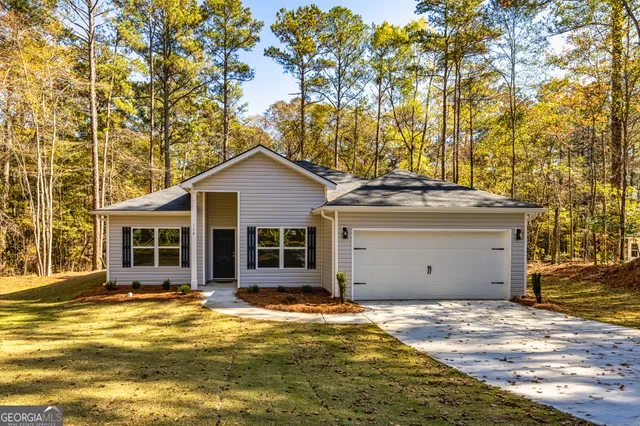 a view of a house with a yard and large tree