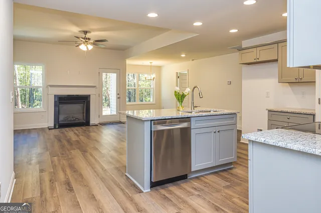 a kitchen with a sink dishwasher a stove and a refrigerator with wooden floor