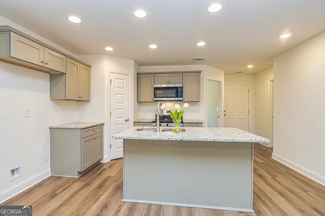 a kitchen with kitchen island sink stove and refrigerator