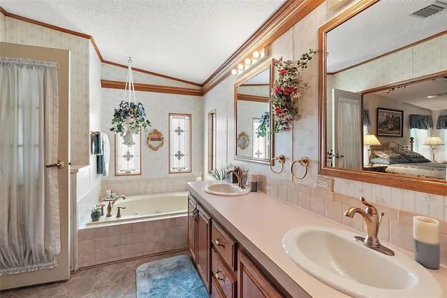 a bathroom with a granite countertop tub sink and mirror
