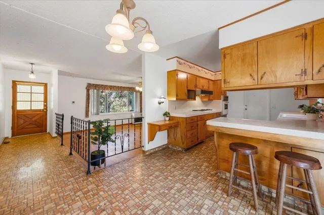 a view of an empty room with wooden floor and a ceiling fan