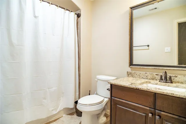 a bathroom with a granite countertop tub sink and mirror