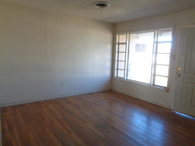 4919 38th Street Lubbock, TX 79414 - Photo 2 of 12 an empty room with wooden floor and windows