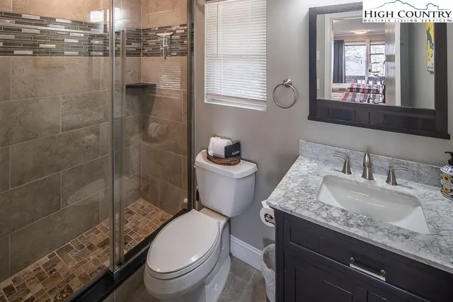 a bathroom with a granite countertop toilet sink and mirror