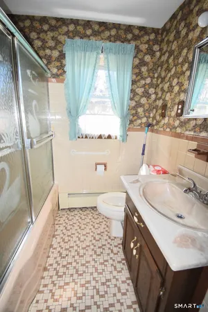 a bathroom with a sink a toilet and shower