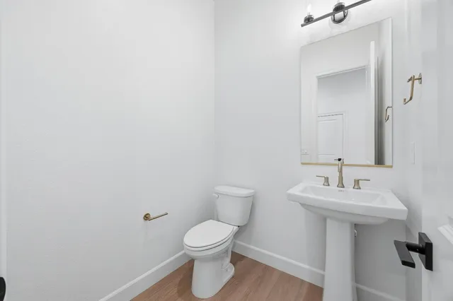 a bathroom with a shower sink vanity mirror and toilet