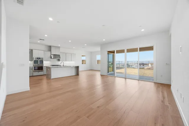 a kitchen with stainless steel appliances granite countertop a stove and a wooden floors