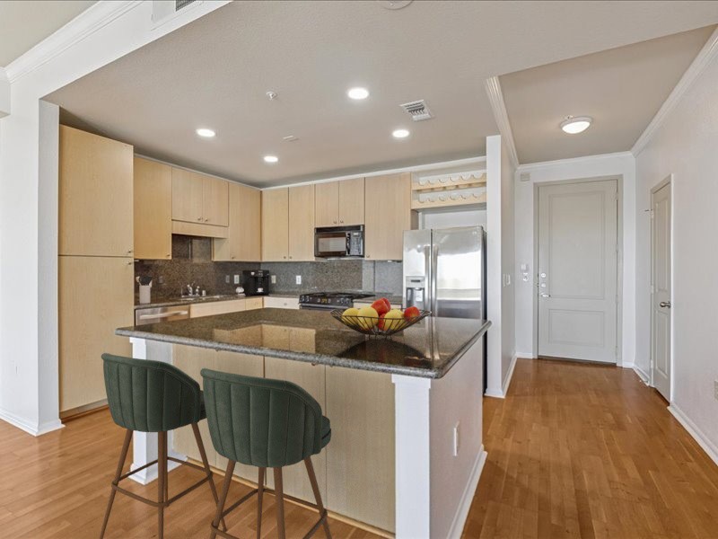 3505 Sage Road, Unit 1603 Houston, TX 77056 - Photo 2 of 28 Designed for both style and function, the kitchen showcases recessed lighting, a spacious island with breakfast bar seating, plentiful cabinets for storage, a wine refrigerator, and elegant granite countertops with a matching backsplash. A perfect blend of practicality and sophistication.