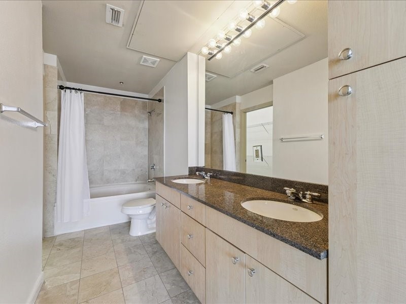 3505 Sage Road, Unit 1603 Houston, TX 77056 - Photo 4 of 28 The spacious primary ensuite features a double vanity, a shower/tub, a large mirror, marble tile flooring with matching backsplash, and a generous walk-in closet.
