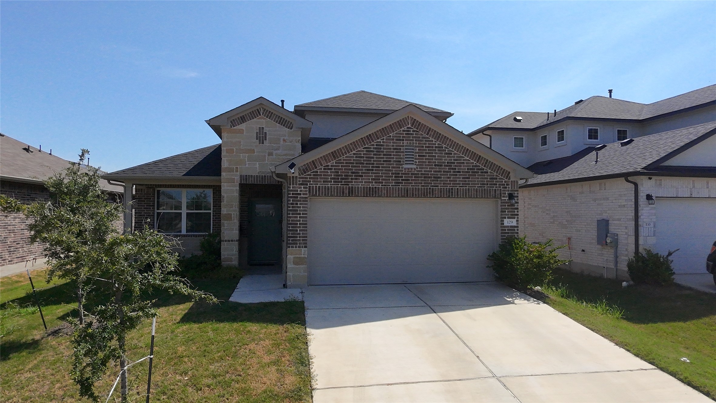 129 Saide Street Georgetown, TX 78626 - Photo 2 of 36 An inviting exterior showcases a detailed brick and stone facade under clean roof lines.