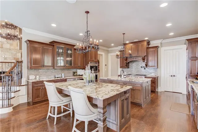 a utility room with stainless steel appliances granite countertop a sink and a window