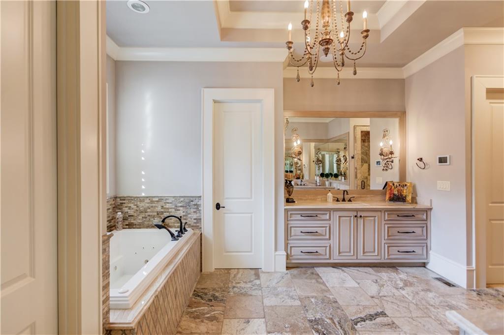 922 Little Darby Lane Suwanee, GA 30024 - Photo 33 of 109 a bathroom with a bathtub a sink and a window