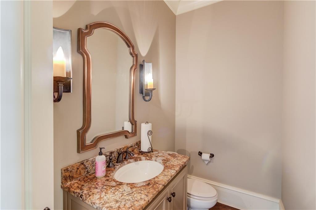 922 Little Darby Lane Suwanee, GA 30024 - Photo 40 of 109 a bathroom with a granite countertop sink a toilet and a mirror