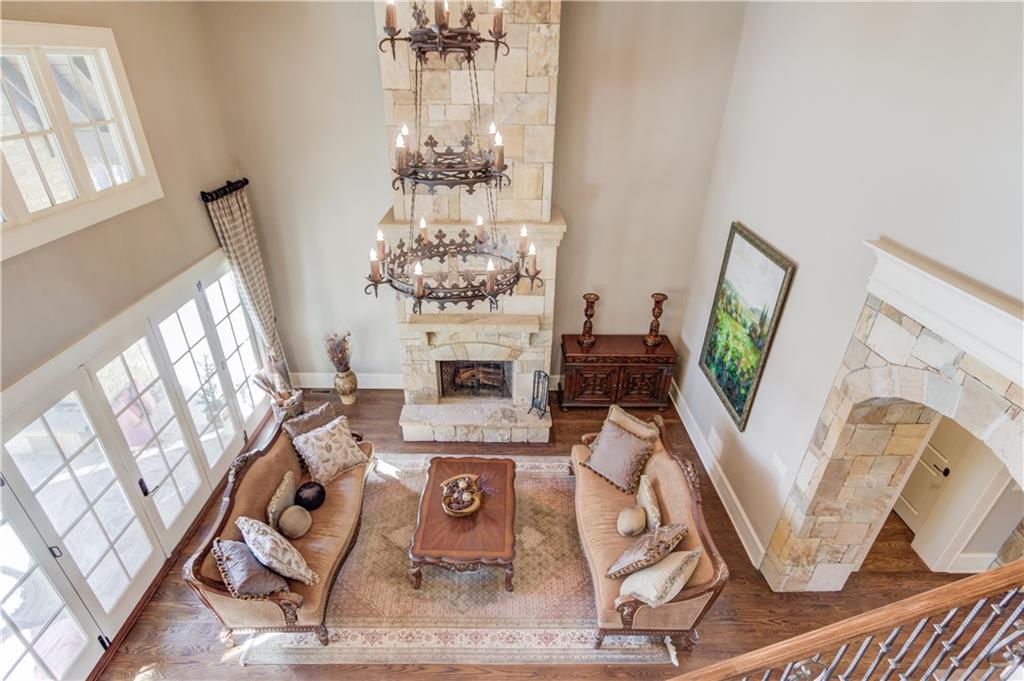 922 Little Darby Lane Suwanee, GA 30024 - Photo 46 of 109 a living room with furniture a fireplace and a chandelier