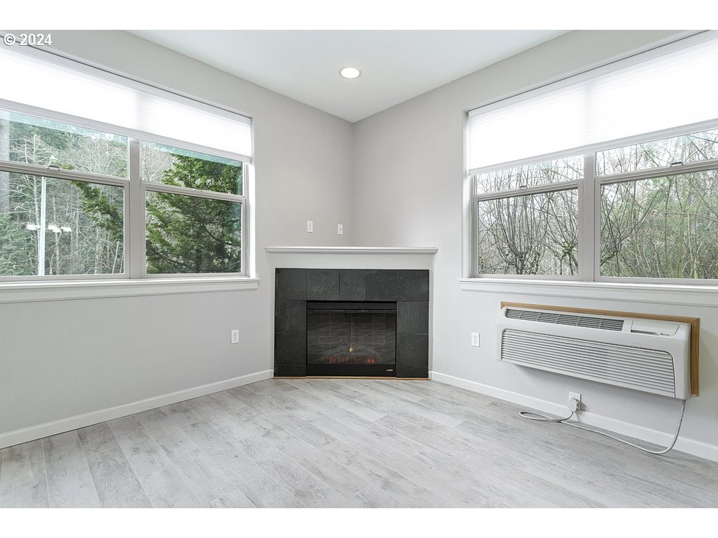 17301 Ruben Lane, Unit 10 Sandy, OR 97055 - Photo 4 of 33 a living room with a fireplace and a floor to ceiling window