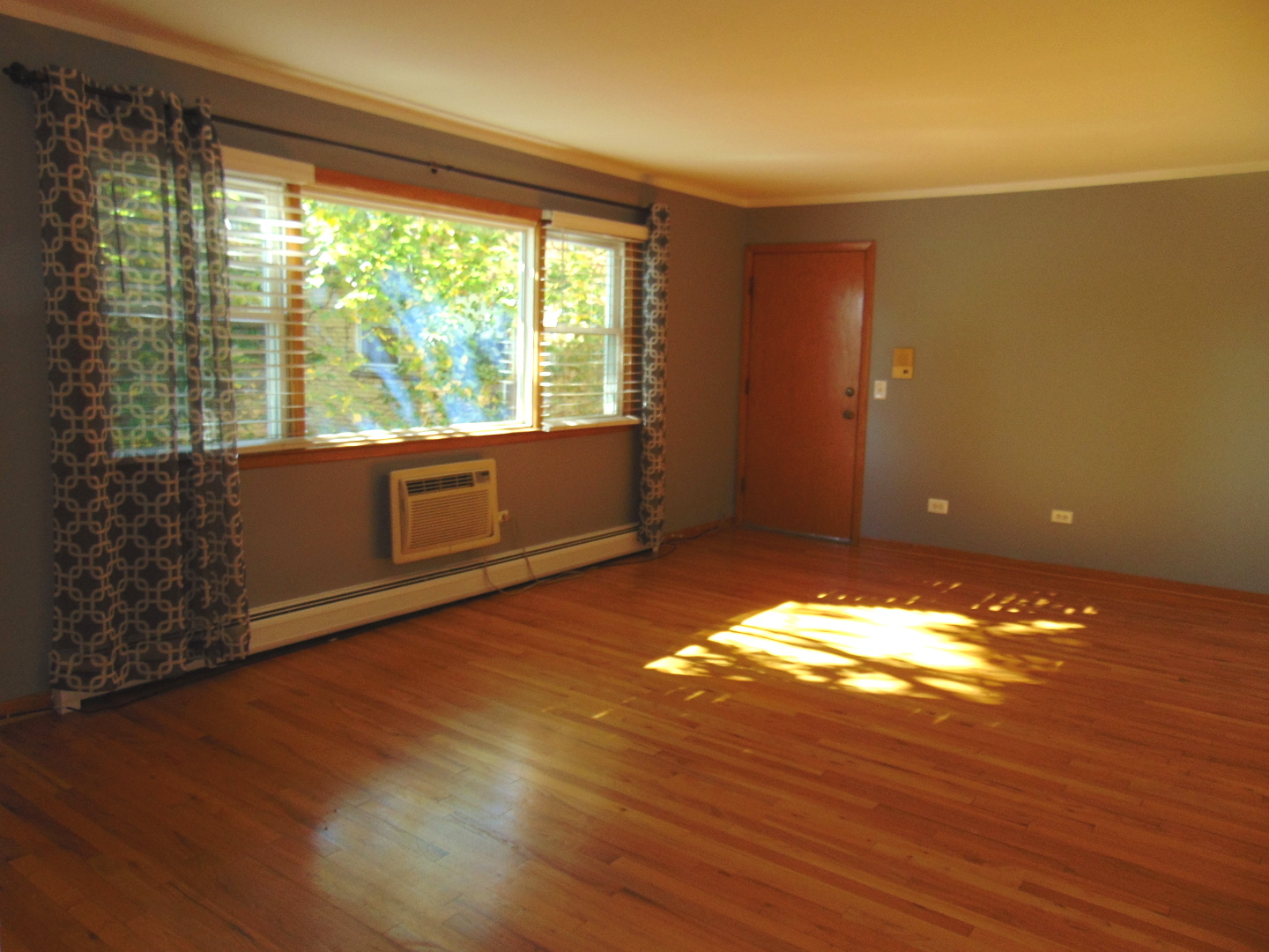 3804 North Harlem Avenue, Unit 4 Chicago, IL 60634 - Photo 9 of 15 a view of an empty room with wooden floor and a window
